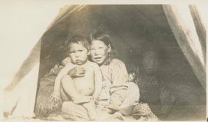 Image of Three children sitting in tent opening